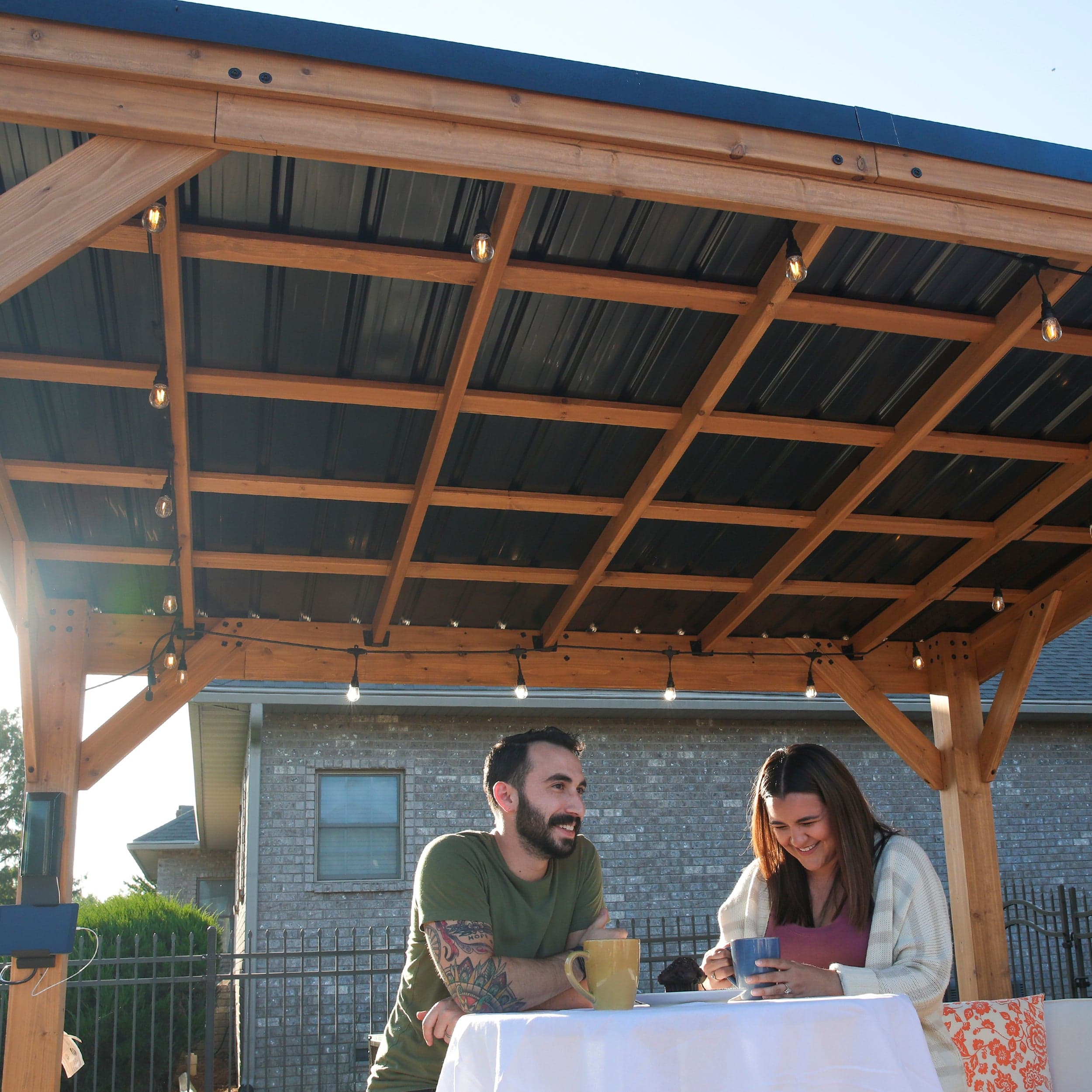 View beneath the steel roof and cedar rafters with an outdoor dining setting