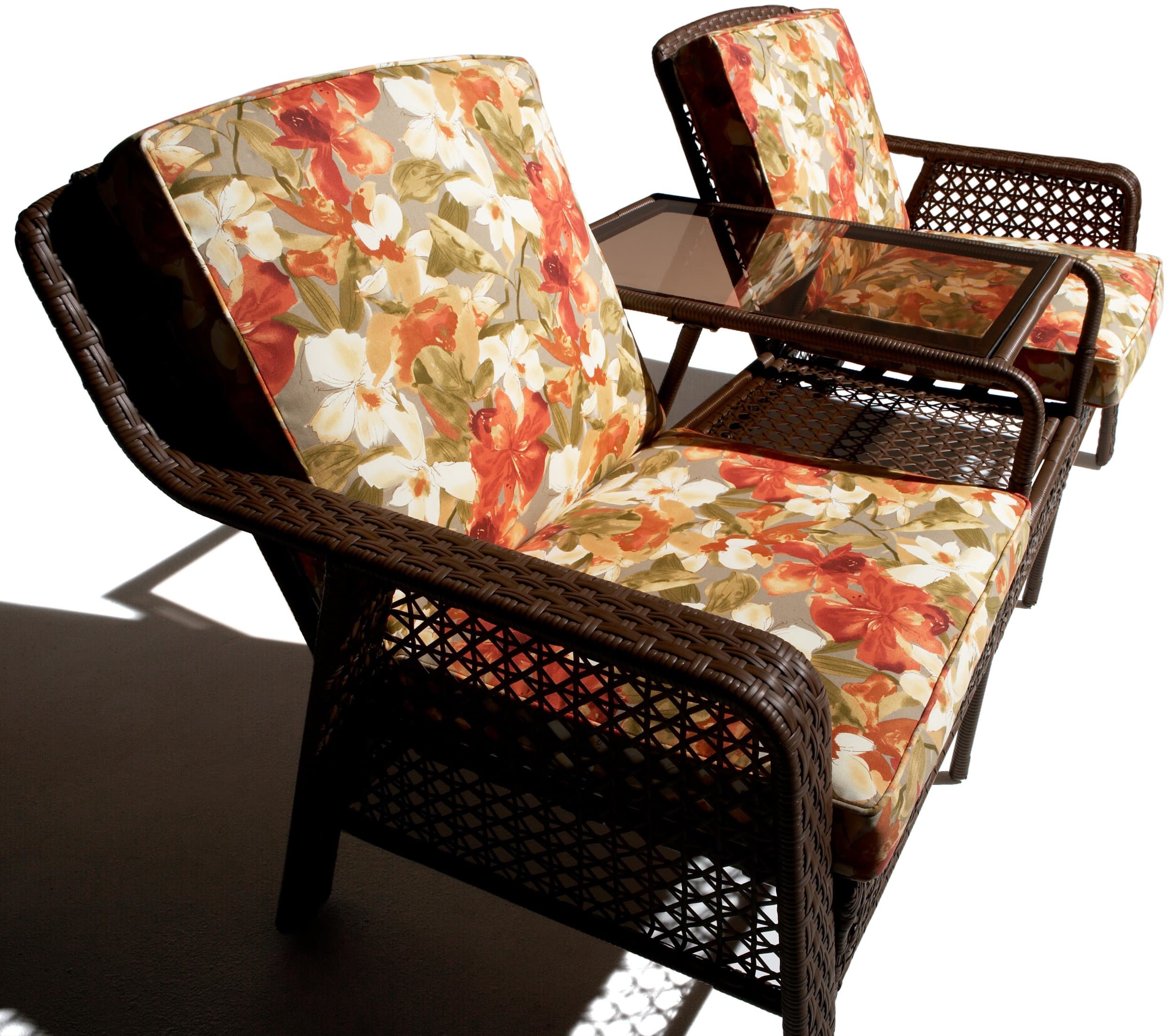 Strathwood Anacapa Resin Wicker Two-Seater Arm Chair and Ottoman Set — angled view of floral cushions and integrated table.