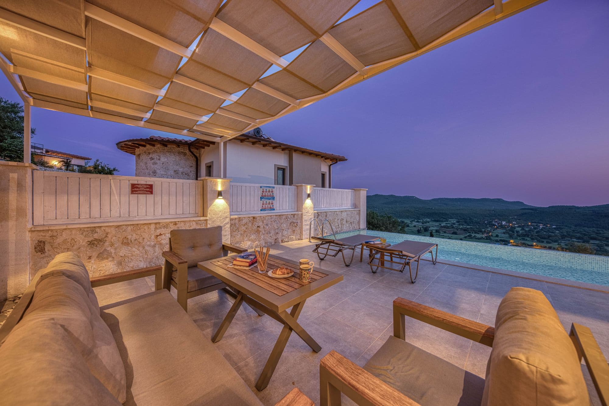 An inviting garden terrace with lounge seating and a shaded pergola
